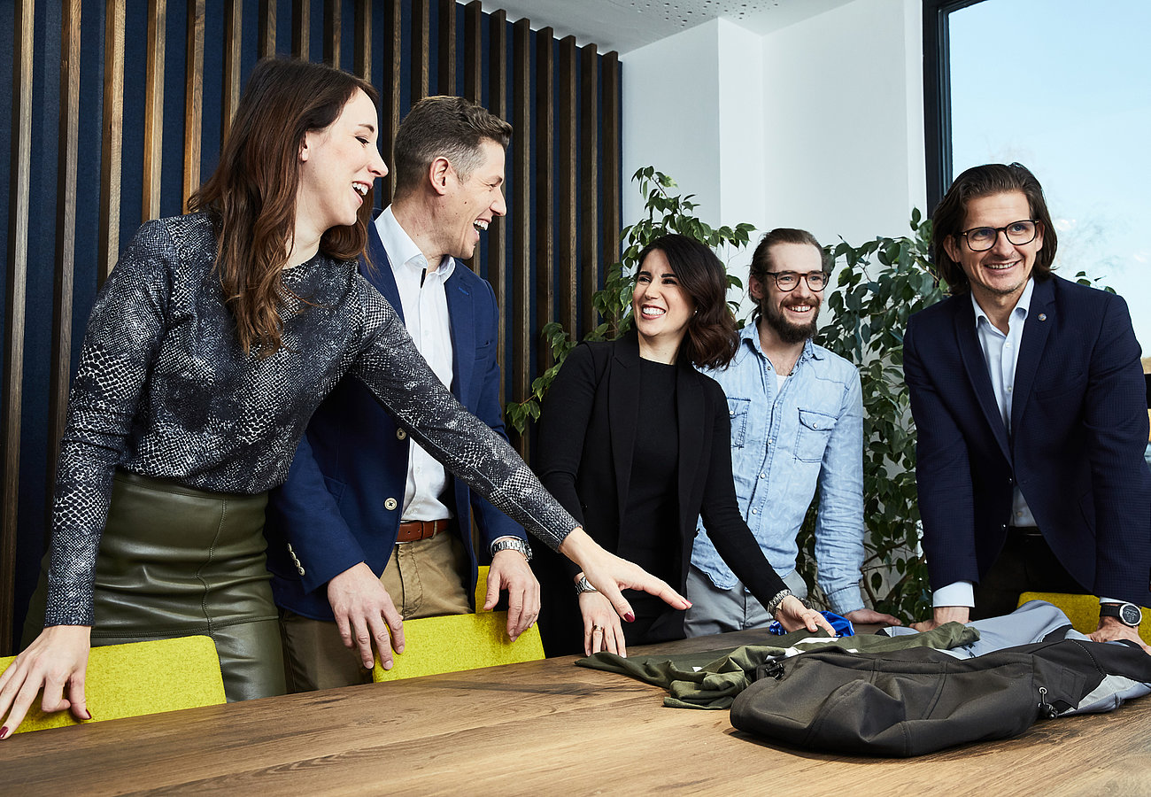 Mitarbeiter stehen zusammen an einem Tisch