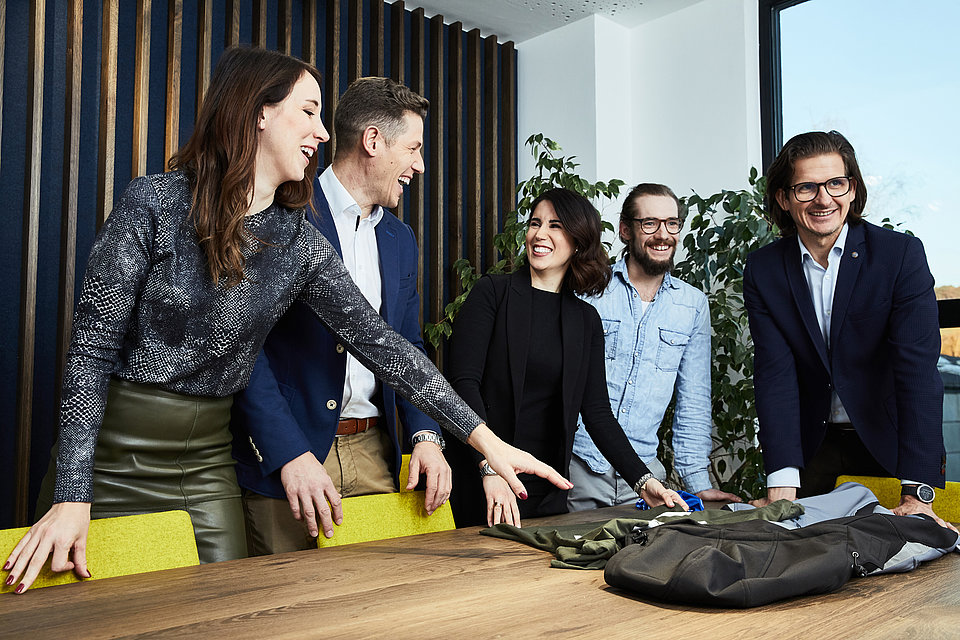 Mitarbeiter stehen zusammen an einem Tisch