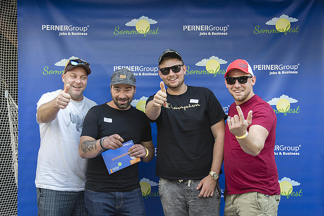 Mitarbeiter beim Sommerfest vor Fotowall